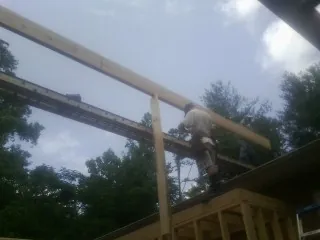 Carpenter setting a ridge beam over a new addition frame — Ice Dam Removal by Roofing Brothers in Englewood