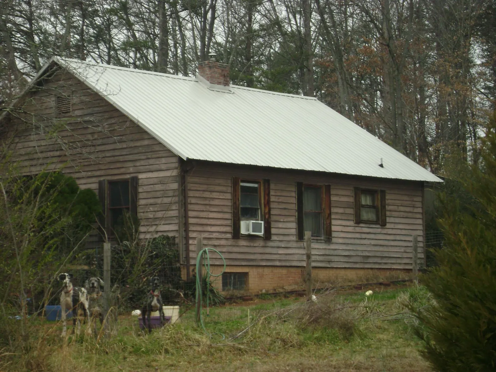 White metal roof on an old wood sided farmhouse, from a Metal Roof Installation job in Englewood